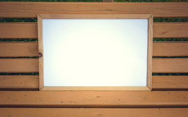 Wooden frame with an empty background on a wooden bench
