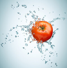 Tomato in spray of water.