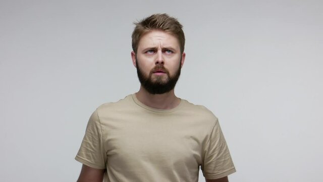 Pensive confused guy leaning hand, rubbing beard while thinking over difficult choice, imagining plan in mind, having doubts, pondering idea looking puzzled clueless. indoor studio shot isolated