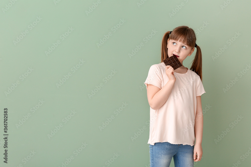 Wall mural Cute funny girl with chocolate on color background