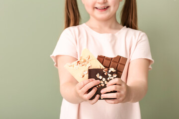 Cute funny girl with chocolate on color background