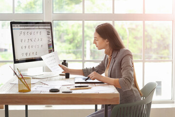 Female calligraphist working in office