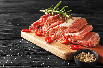 Raw beef short ribs with spices on dark wooden background