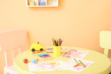 Table with paints and pencils in kindergarten