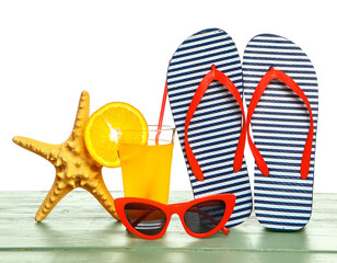 Set of beach accessories on table against white background