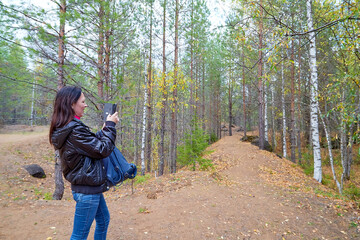 Beautiful young woman walking in the forest with sprice in autumn