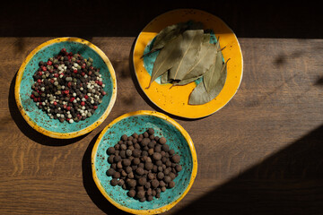 Ziele angielskie pieprz kolorowy liść laurowy na ceramicznych talerzykach