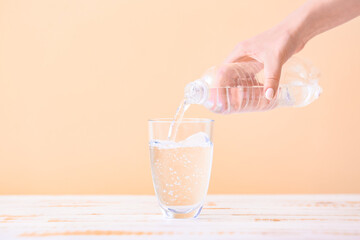 Pouring of water into glass on table