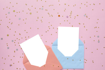 two white blank cards in envelope on pink background with golden confetti. Holiday mockup. Top view.