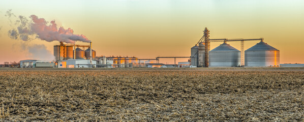 Ethanol plant in an agricultural landscape.  - obrazy, fototapety, plakaty