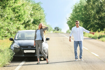 Young couple near broken car on road