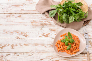 Plate with tasty pasta and tomato sauce on table