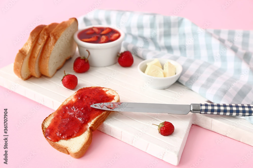 Wall mural board with tasty strawberry jam, bread and butter on color background