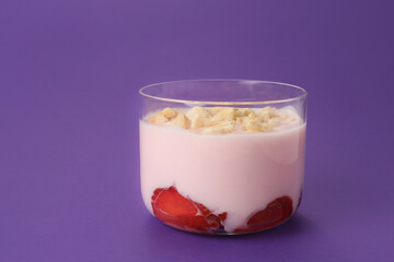 Glass of healthy strawberry yogurt on color background