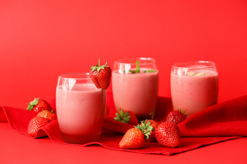 Glasses of tasty strawberry smoothie on color background