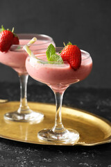 Glasses of tasty strawberry smoothie on dark background
