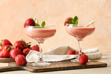 Glasses of tasty strawberry smoothie on table