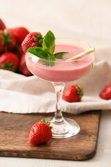 Glass of tasty strawberry smoothie on table