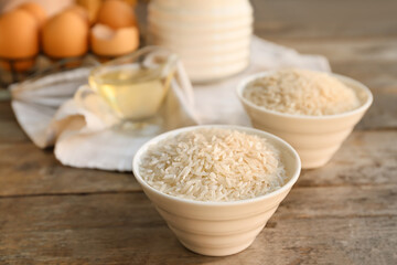 Fototapeta na wymiar Bowl with raw rice on table