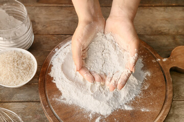 Woman with rice flour at table, top view