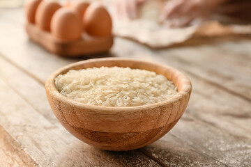 Bowl with raw rice on table