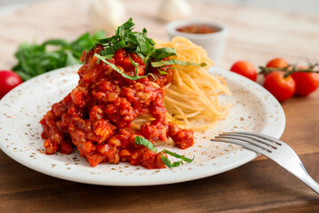 Plate with tasty pasta bolognese on table, closeup
