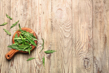 Board with fresh arugula on wooden background