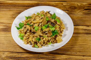 Tasty risotto with mushrooms on wooden table