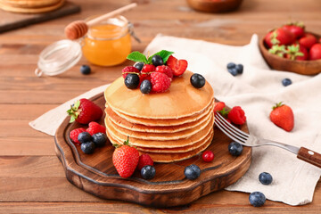 Sweet pancakes with berries on table