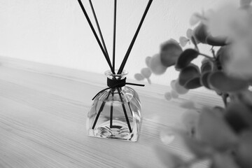 nice reed diffuser decorate with a plant on the wooden table in the bed room