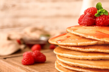 Sweet pancakes with berries on table, closeup