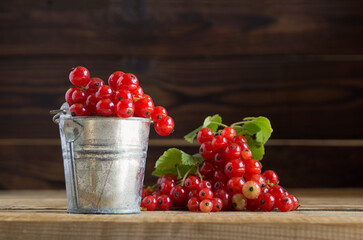 ripe red currants on a wooden background