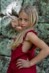 Porträt eines jungen, hübschen, manchmal nachdenklich oder frechen Mädchens in einem schicken roten Kleid.