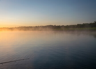 Foggy weather early in the morning on the lake. beautiful wallpapers. a mystical mist vibrates in the lake. summer sunrise