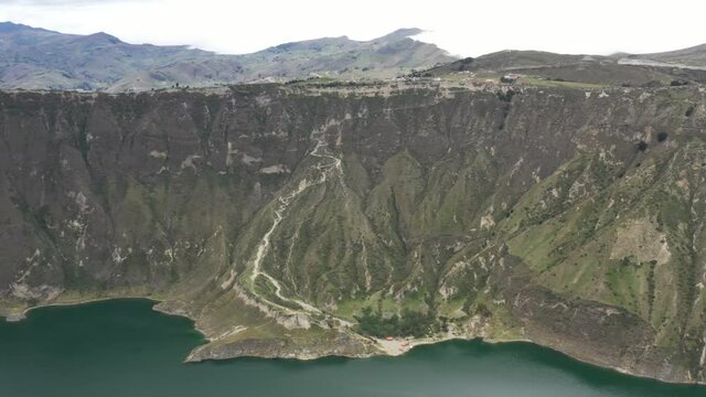 Aerial view showing the crater of the vulcano Quilotoa in Ecuador by slowly turning around the camera
