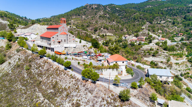 Aerial view of Agios Arsenios church, Kyperounda village, Limassol, Cyprus. Traditional landmark christian greek orthodox, ceramic tiled roof, stone bell tower architecture in Kyperounta from above