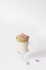 Dalgon's trending drink is coffee. Coffee mug, lilac and marshmallow on a white background.