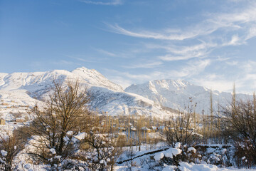 Beautiful mountain landscape in winter in Uzbekistan in the area of mount Chimgan. Cirrus clouds in a blue sky