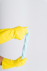 Cleaner hand wearing yellow protective glove holding blue rag cloth isolate over white background.