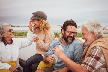 Family group of four people have fun and smile together outdoor on terrace. Parents and senior grandparents love and harmony concept