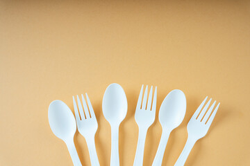 Group of plastic spoon and fork over orange background. Copy space.