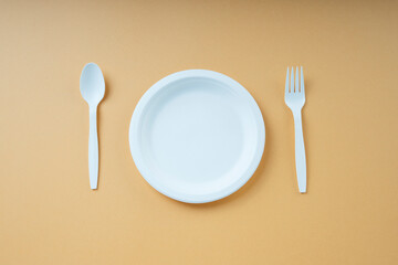 Top view - Plastick plate and spoon and fork. Disposable untensil.