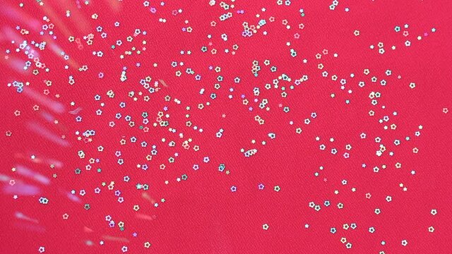 Multicolored shiny glitter confetti dots rain. Golden sparkling glittering border isolated on red background. Party tinsels shimmer, holiday background design, festive frame