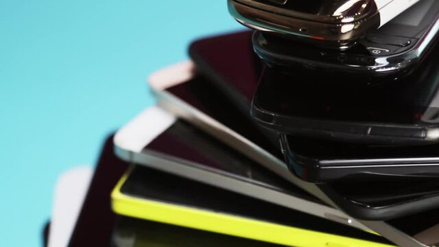 outdated and modern models of smartphones and mobile phones. dirty, broken and old smartphones on a blue background. Rotation