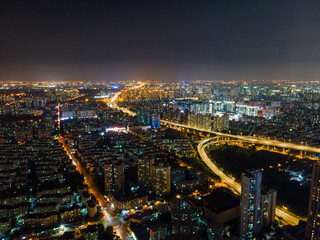 Fototapeta na wymiar Aerial view of Shanghai cityscape & night-scape. Futuristic modern city view. Downtown residential buildings and avenue highways in the night. Modern futuristic city view with neon and traffic lights