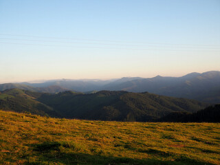 Pradera con montañas al fondo al atardecer.