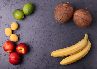diffrent fresh natural tropical fruits on stone dark grey surface