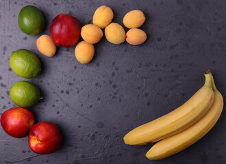 diffrent fresh natural tropical fruits on stone dark grey surface