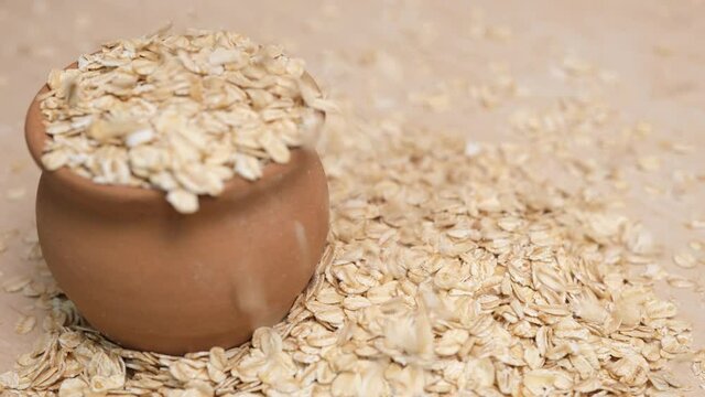 Rolled oats grains in a faience pot. 4k video shot.