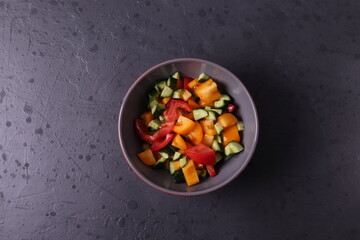 a bowl of vegen vegetable salad on  dark grunge stone background